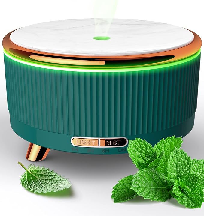 Green essential oil diffuser with a marble top and gold accents, emitting mist with mint leaves placed beside it